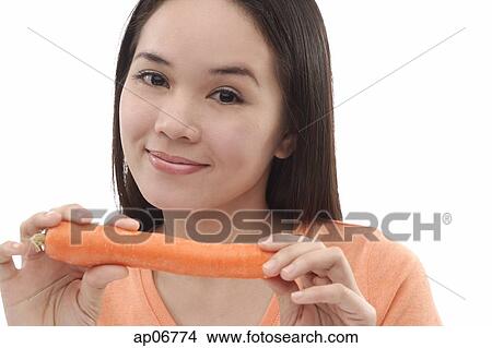 Young woman holding a carrot View Large Photo Image Picture - Young woman holding a carrot. Fotosearch