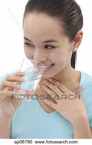 Young woman holding a glass of water View Large Photo Image Stock Image - Young woman holding a glass of water. Fotosearch