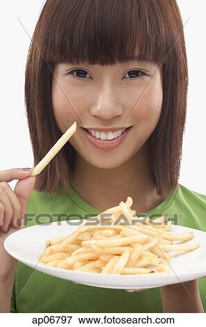 Young woman holding a plate of French fries View Large Photo Image Stock Photo - Young woman holding a plate of French fries. Fotosearch