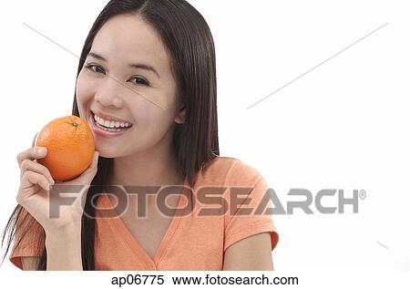 Young woman holding an orange View Large Photo Image Stock Photography - Young woman holding an orange. Fotosearch