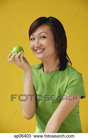 Young Woman holding apple View Large Photo Image Stock Image - Young Woman holding apple. Fotosearch