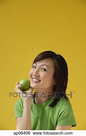 Stock Photograph - Young Woman holding apple. Fotosearch