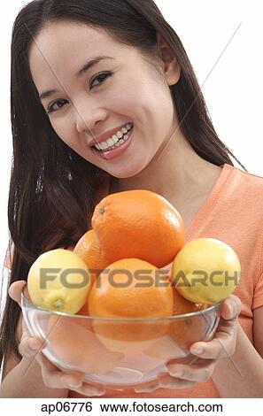 Young woman holding bowl of oranges and lemons View Large Photo Image Stock Photograph - Young woman holding bowl of oranges and lemons. Fotosearch