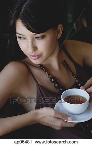 Young woman holding cup and saucer View Large Photo Image Stock Image - Young woman holding cup and saucer. Fotosearch