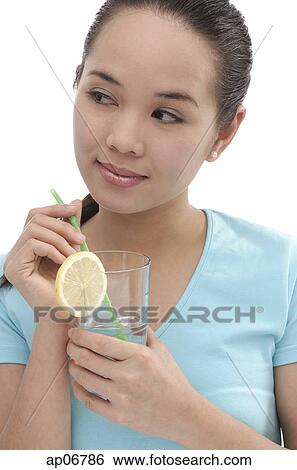Young woman holding drink, looking away View Large Photo Image Stock Photograph - Young woman holding drink, looking away. Fotosearch