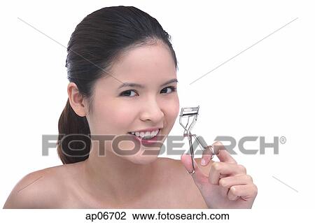 Young woman holding eyelash curler View Large Photo Image Stock Image - Young woman holding eyelash curler. Fotosearch