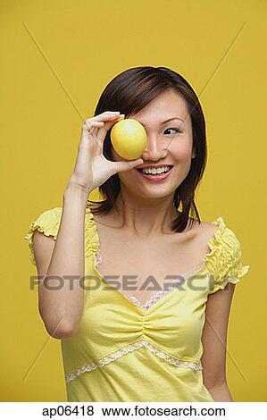 Young woman holding lemon over her eye View Large Photo Image Stock Photo - Young woman holding lemon over her eye. Fotosearch