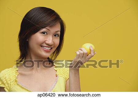 Young woman holding lemon, smiling View Large Photo Image Stock Image - Young woman holding lemon, smiling. Fotosearch