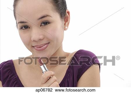Young woman holding lipstick tube View Large Photo Image Stock Image - Young woman holding lipstick tube. Fotosearch