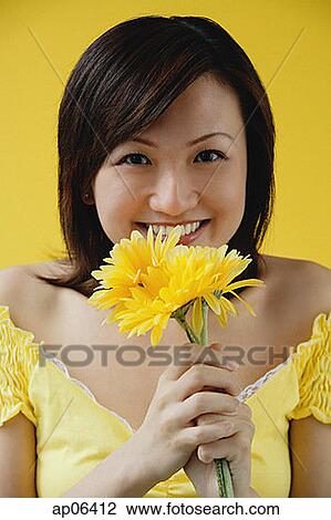 Young woman holding yellow flowers View Large Photo Image Stock Image - Young woman holding yellow flowers. Fotosearch
