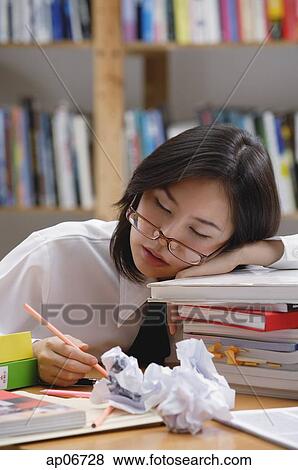Young woman in library, sleeping on stack of books View Large Photo Image Stock Photo - Young woman in library, sleeping on stack of books. Fotosearch