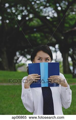 Young woman in school uniform, book covering face, looking away View Large Photo Image Stock Photography - Young woman in school uniform, book covering face, looking away. Fotosearch