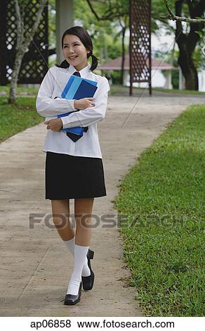 Young woman in school uniform, walking on path View Large Photo Image Stock Photo - Young woman in school uniform, walking on path. Fotosearch