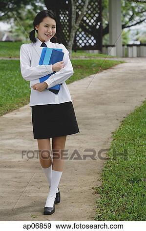 Young woman in school uniform, walking on path, smiling at camera View Large Photo Image Stock Photo - Young woman in school uniform, walking on path, smiling at camera. Fotosearch