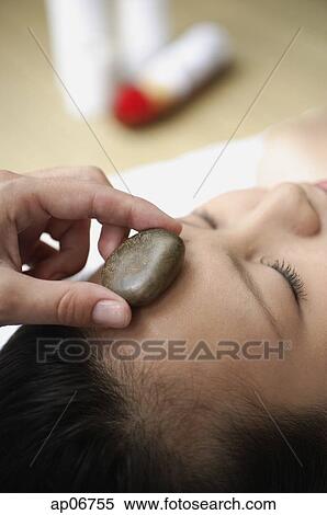Young woman in spa, massage stone being placed on her forehead View Large Photo Image Stock Photography - Young woman in spa, massage stone being placed on her forehead. Fotosearch
