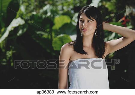 Young woman in tropical garden, looking away View Large Photo Image Stock Photo - Young woman in tropical garden, looking away. Fotosearch