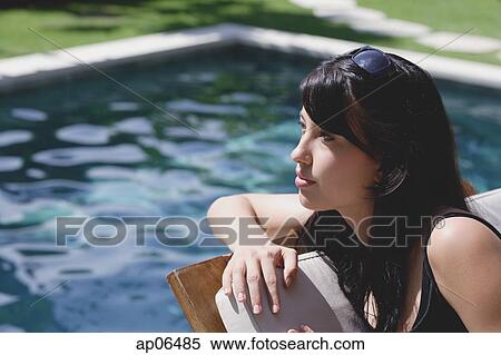 Young woman leaning on deck chair by swimming pool View Large Photo Image Stock Photography - Young woman leaning on deck chair by swimming pool. Fotosearch