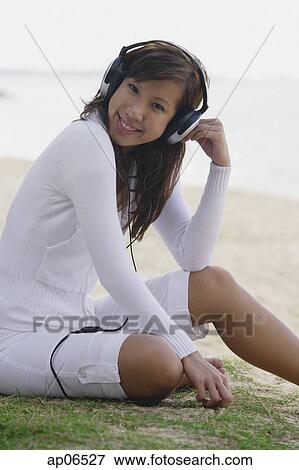 Young woman listening to music, wearing headphones View Large Photo Image Stock Photo - Young woman listening to music, wearing headphones. Fotosearch