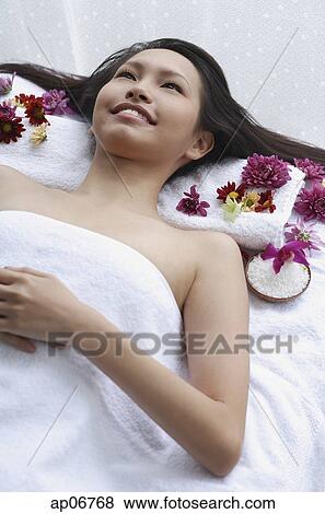Young woman lying down on massage table, looking up View Large Photo Image Stock Photo - Young woman lying down on massage table, looking up. Fotosearch
