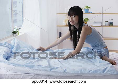 Young woman making her bed View Large Photo Image Picture - Young woman making her bed. Fotosearch