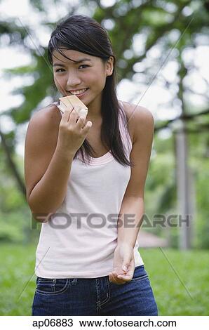 Young woman outdoors, eating ice cream View Large Photo Image Stock Image - Young woman outdoors, eating ice cream. Fotosearch