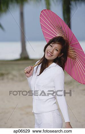 Young woman outdoors, using pink umbrella View Large Photo Image Stock Photo - Young woman outdoors, using pink umbrella. Fotosearch