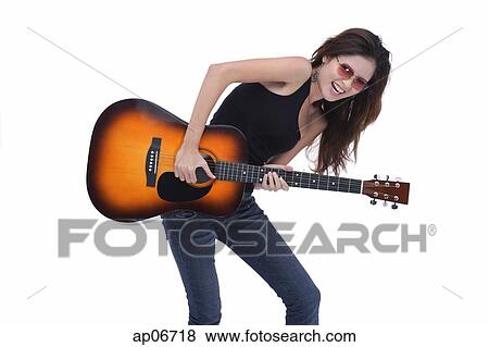 Stock Photo - Young woman playing guitar, studio shot. Fotosearch