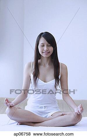 Young woman sitting in yoga position, meditating View Large Photo Image Stock Photo - Young woman sitting in yoga position, meditating. Fotosearch