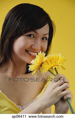 Young woman smelling flowers View Large Photo Image Stock Image - Young woman smelling flowers. Fotosearch
