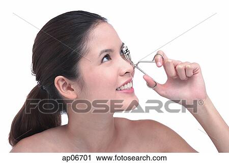 Young woman using eyelash curler View Large Photo Image Stock Image - Young woman using eyelash curler. Fotosearch