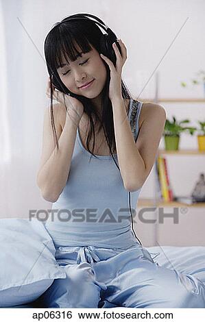 Young woman using headphones, eyes closed View Large Photo Image Stock Photograph - Young woman using headphones, eyes closed. Fotosearch