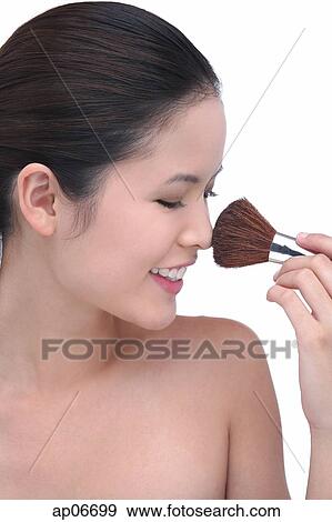 Young woman using make-up brush View Large Photo Image Stock Photo - Young woman using make-up brush. Fotosearch