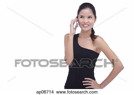 Young woman using mobile phone, hands on hip View Large Photo Image Picture - Young woman using mobile phone, hands on hip. Fotosearch