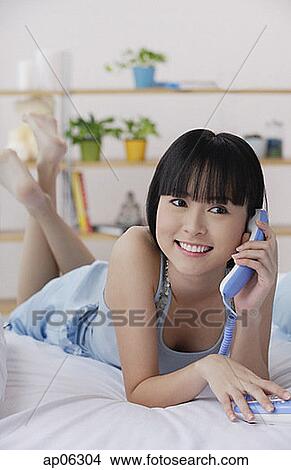 Young woman using telephone, smiling View Large Photo Image Picture - Young woman using telephone, smiling. Fotosearch