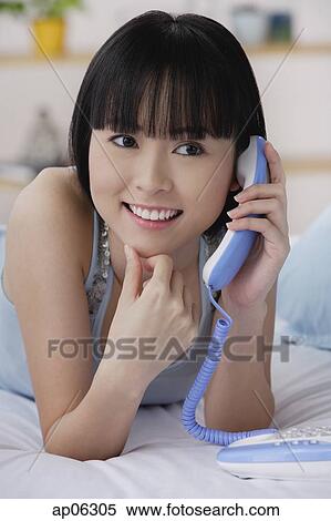 Young woman using telephone, smiling View Large Photo Image Stock Photography - Young woman using telephone, smiling. Fotosearch