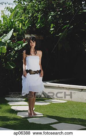 Young woman walking in tropical garden, smiling at camera View Large Photo Image Stock Photo - Young woman walking in tropical garden, smiling at camera. Fotosearch