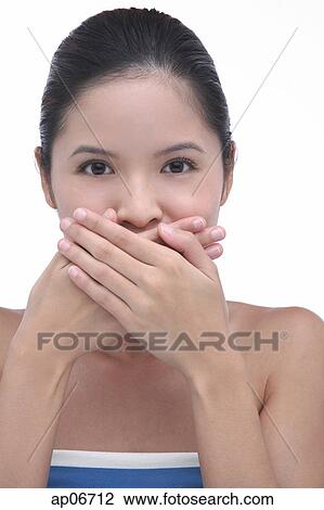 Young woman with hands over mouth, looking at camera View Large Photo Image Stock Image - Young woman with hands over mouth, looking at camera. Fotosearch