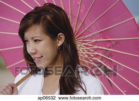 Young woman with pink umbrella, looking away View Large Photo Image Stock Image - Young woman with pink umbrella, looking away. Fotosearch