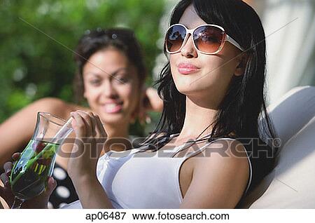 Young women sitting on deck chairs View Large Photo Image Stock Photo - Young women sitting on deck chairs. Fotosearch