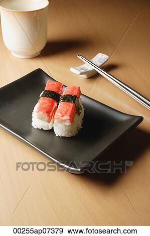 2 pieces of sushi, Kanikama Nigiri, crabstick on tray with chopsticks and tea View Large Photo Image Stock Photo - 2 pieces of sushi, Kanikama Nigiri, crabstick on tray with chopsticks and tea. Fotosearch