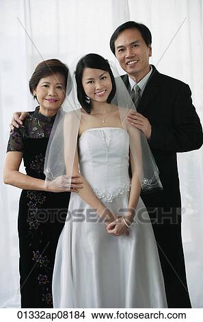 A bride and her family smile at the camera together View Large Photo Image Picture - A bride and her family smile at the camera together. Fotosearch