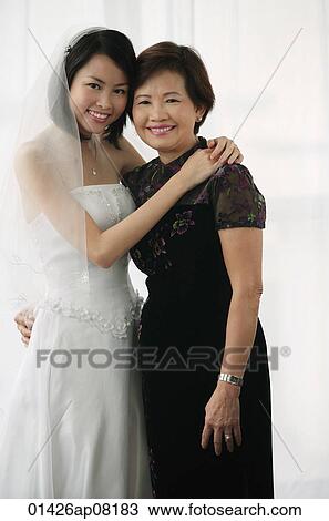 A bride and her mother smile at the camera together View Large Photo Image Stock Image - A bride and her mother smile at the camera together. Fotosearch