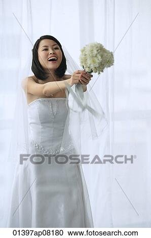 A bride holds out a bouquet of flowers View Large Photo Image Stock Image - A bride holds out a bouquet of flowers. Fotosearch