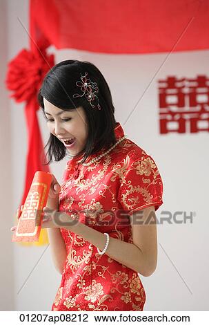 A bride looks excited as she looks inside a red envelope View Large Photo Image Stock Image - A bride looks excited as she looks inside a red envelope. Fotosearch