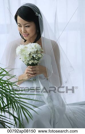 A bride smiles as she holds a bouquet of flowers View Large Photo Image Stock Image - A bride smiles as she holds a bouquet of flowers. Fotosearch