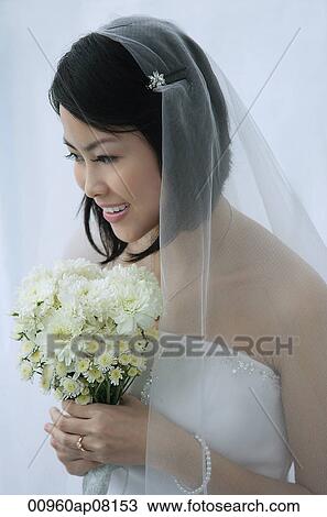 A bride smiles as she holds a bouquet of flowers View Large Photo Image Stock Image - A bride smiles as she holds a bouquet of flowers. Fotosearch