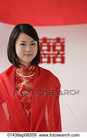 A bride wearing a red silk dress looks at the camera View Large Photo Image Stock Photo - A bride wearing a red silk dress looks at the camera. Fotosearch