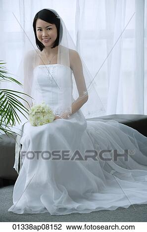 A Bride With A White Wedding Gown Sits Down And Smiles At The