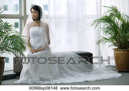 A bride with a white wedding gown sits down View Large Photo Image Stock Photo - A bride with a white wedding gown sits down. Fotosearch