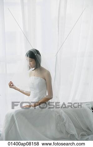 A bride with a white wedding gown sits down View Large Photo Image Stock Photo - A bride with a white wedding gown sits down. Fotosearch